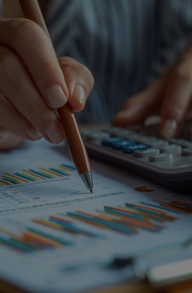 A person calculates with a calculator and pen while writing on a sheet of paper.