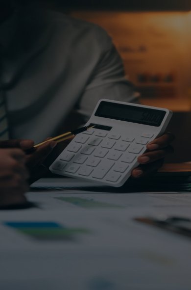 A man engaged in mathematical calculations with a calculator, showcasing his attention to detail and problem-solving abilities.